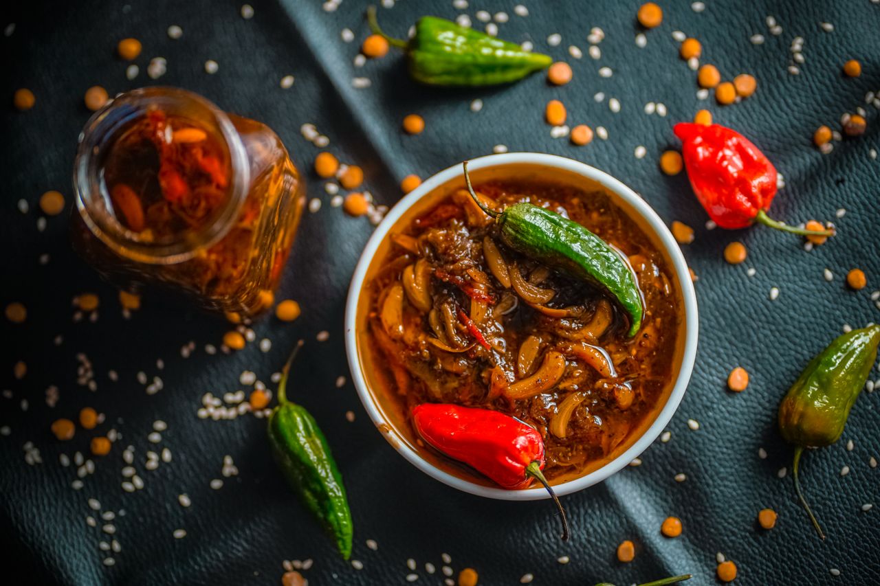 A vibrant bowl of spicy homemade pickle with fresh chilies and aromatic spices, embodying Bangladeshi flavors.